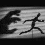 picture of a man being chased by a shadow, fear or phobia